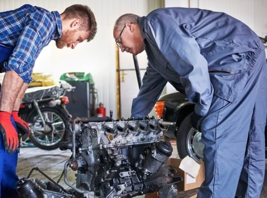 mechanics-repairing-car-workshop_329181-11800