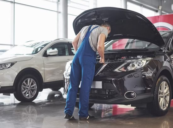 muscular-car-service-worker-repairing-vehicle_146671-19604